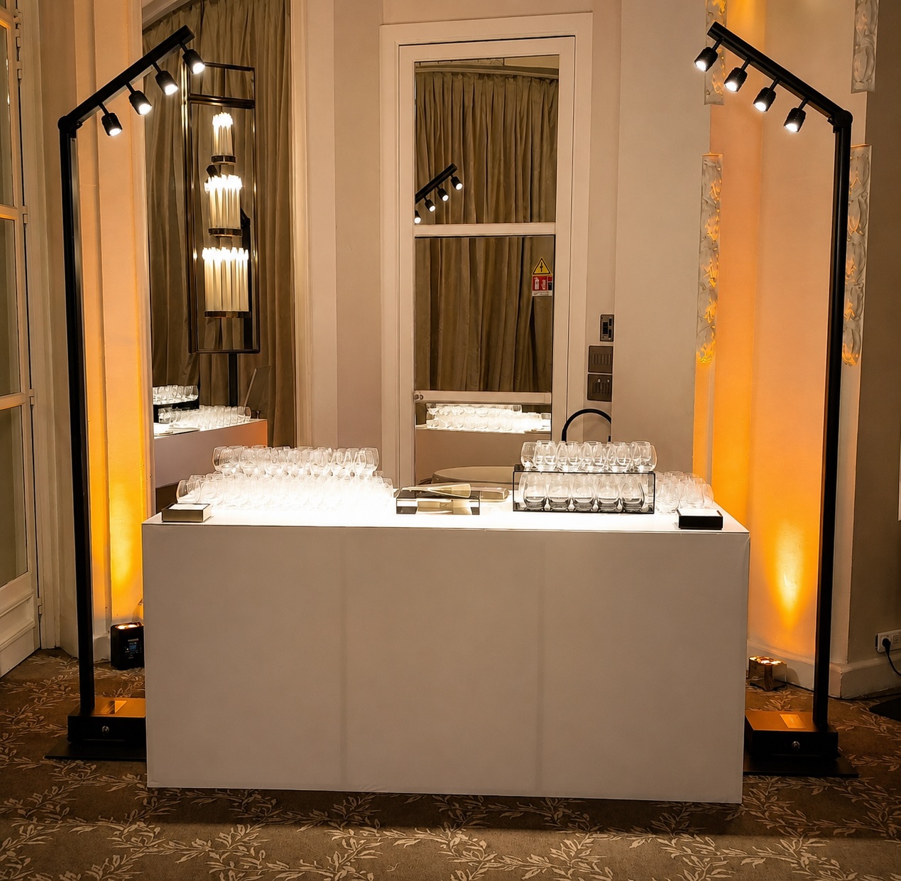 Mise en lumière d'un buffet lors d'un événement d'entreprise, mâts d'éclairage et ambiance dorée.