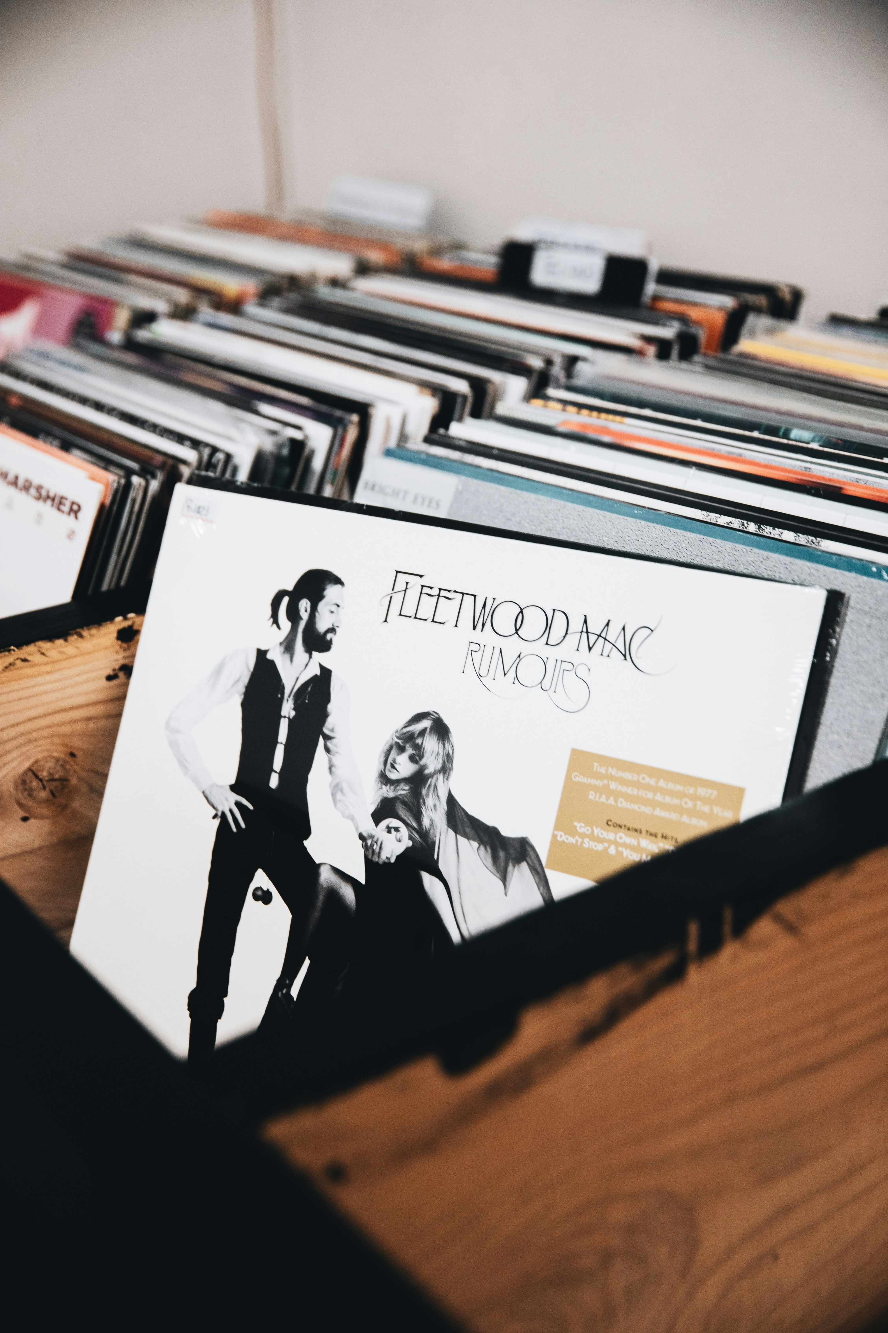 Bac de vinyles dans un bar à disques, pochette de l'album Rumours de Fleetwood Mac au premier plan.