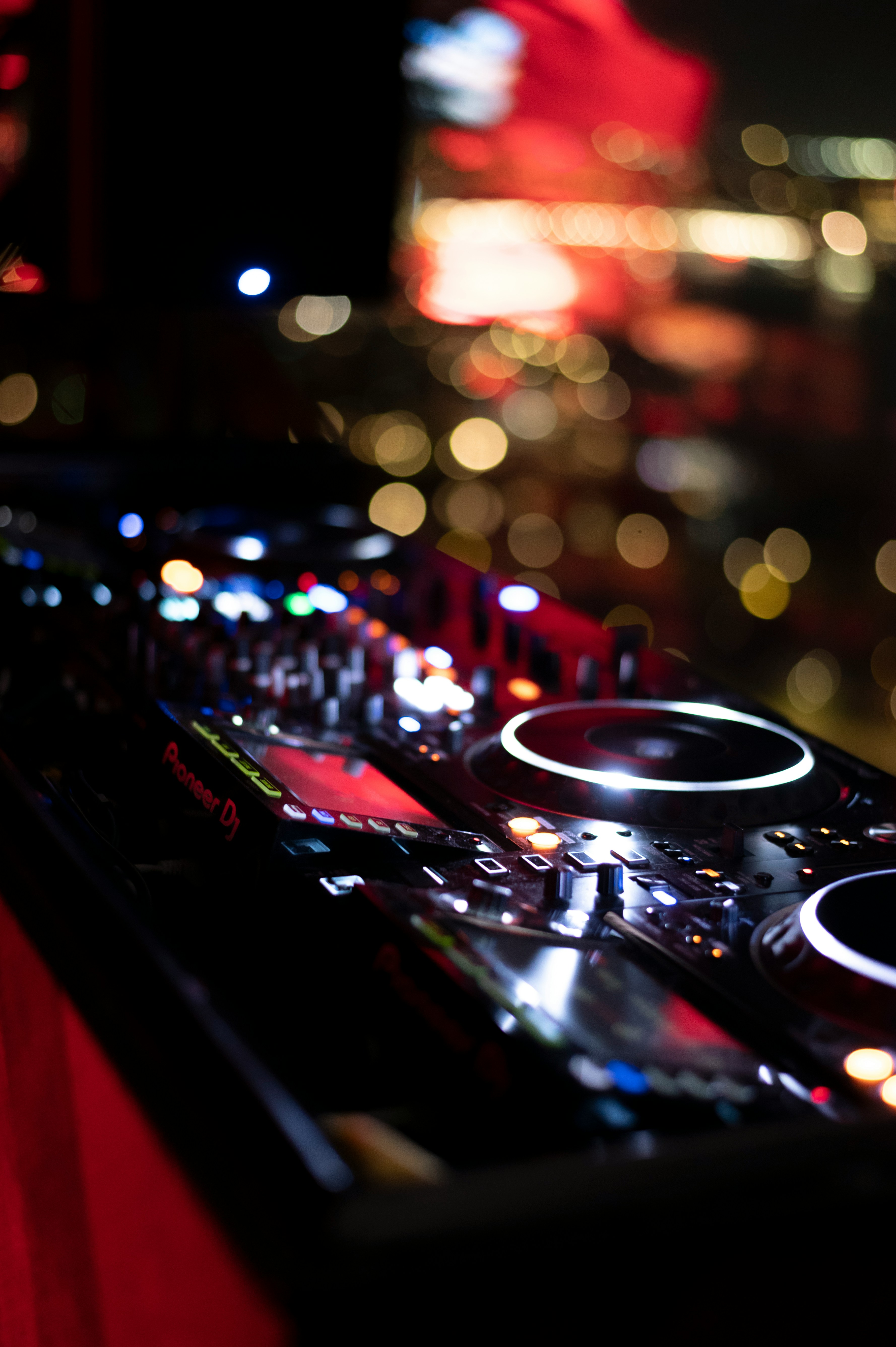 Platines et mixette DJ en gros plan, ambiance nocturne d'une soirée privée.