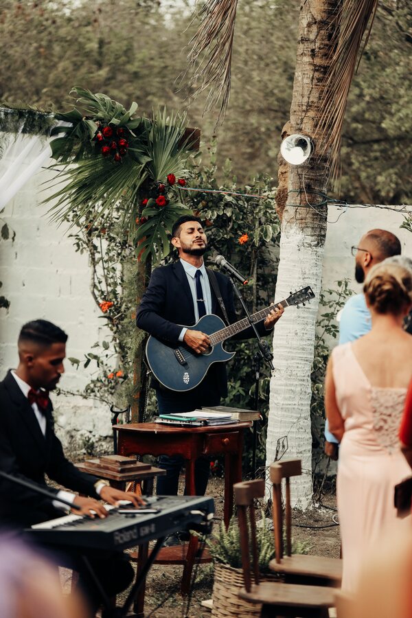 Artiste live chantant et jouant de la guitare en extérieur pendant une cérémonie de mariage.
